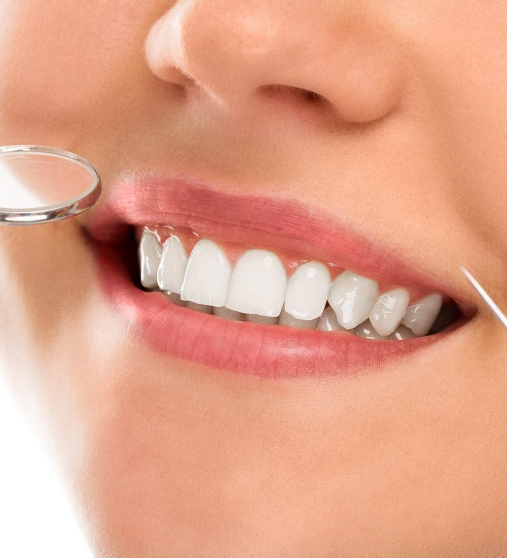 A woman is smiling while being at the dentist